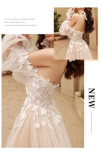 Close-up of 3D floral appliqués and delicate lace embroidery on champagne tulle dress