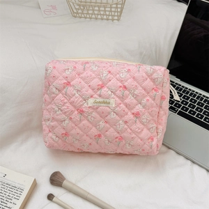 Detailed close-up of pink quilted floral makeup bag with cute white rabbit patterns