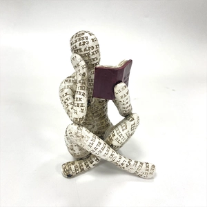 Detailed view of resin sculpture featuring a woman reading with letter patterns