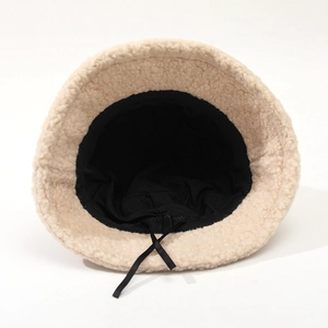 Solid color sherpa bucket hat in beige with black lining and adjustable drawstring cord