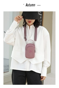 Detail of dusty pink nylon crossbody bag with adjustable wide strap and round logo patch