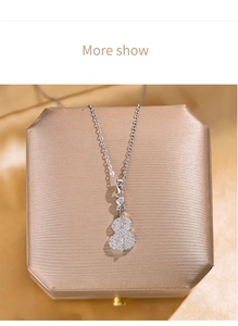 Macro view of silver guitar pendant necklace with clear crystals on a jewelry box