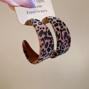 Gros plan détaillé des boucles d'oreilles en C à motif léopard avec texture velours