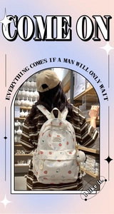 Detail of cute strawberry print backpack with plush pendant and adjustable shoulder straps