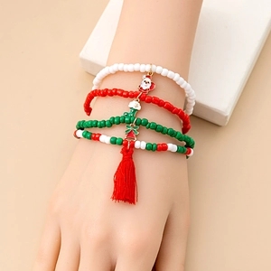 Detail of Christmas beaded bracelet set with Santa Claus, stockings, and red tassel charms