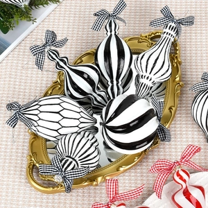 Elegant black, white and red striped Christmas ball ornaments on a vintage gold mirror tray