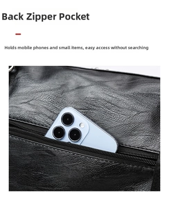 Close-up of rear zipper pocket on black leather travel bag holding a smartphone
