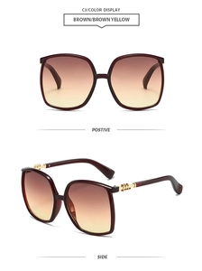 Detail view showing gold metal geometric accents on oversized brown gradient sunglasses