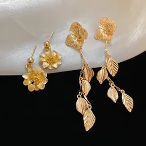Elegant gold flower and leaf tassel earrings with matte finish and plant-inspired design