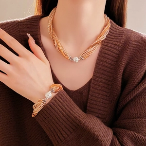 Détail de parure collier et bracelet multi-rangs en cristal ambré et fermoirs strass