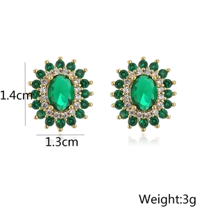 Macro detail of geometric earrings featuring green zircons and 1.4cm x 1.3cm dimensions