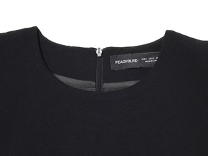 Detail shot of black knit dress neckline with back zipper and interior size label