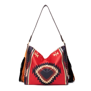 Close-up of bohemian shoulder bag with ethnic heart pattern and colorful long fringe detail