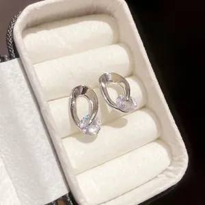 Minimalist silver needle earrings with irregular metal hoops and clear zircon stones