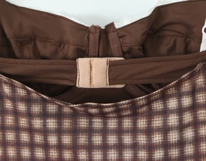 Vista de detalle del top a cuadros marrones con tirante ajustable y hebilla de color beige