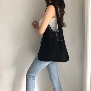 Minimalist black knit tote bag with mesh hollow design shown on a shoulder