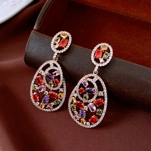 Macro detail of vintage oval earrings with colorful zircon gemstones and gold finish