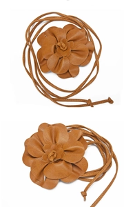 Detail view of a brown leather waist belt featuring a decorative flower knot design