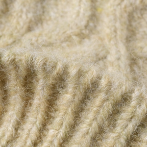 Close-up of thick cream ribbed knit beanie with soft mohair texture and warm fluffy finish
