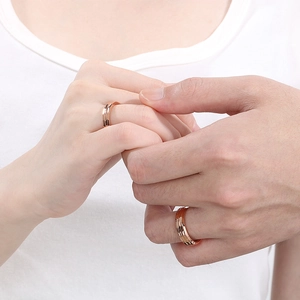 Minimalist textured rose gold couple rings set on hands with a warm romantic aesthetic