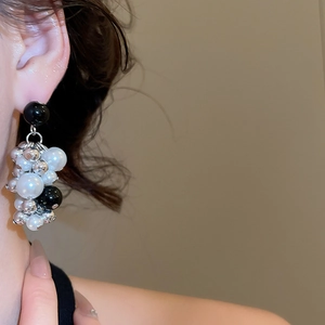 Close-up of cluster beaded earrings with pearls and silver metallic beads on model