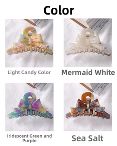 Detail view of four colored acetate bow hair claws in macaron, pearl white, and amber tones
