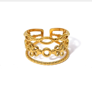 Macro shot of gold-plated multi-layer open ring featuring flower and geometric motifs