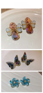 Detailed close-up showing bee, butterfly, and flower crystal earrings in varied gemstone colors