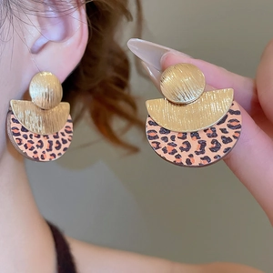 Détail de boucles d'oreilles rétro en métal doré brossé avec motif léopard élégant