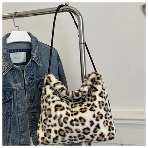Detailed texture of leopard print faux fur tote bag hanging next to denim jacket