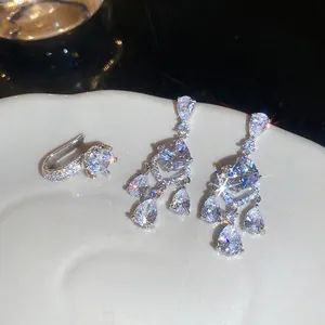Elegant silver tassel earrings and ring set with pear-cut cubic zirconia in a ceramic tray