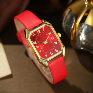 Detailed macro view of the octagon gold watch case with red dial and leather strap