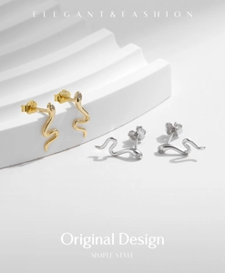 Macro shot of S925 sterling silver snake earrings in gold and silver finish with CZ eyes