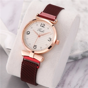 Detailed side view of rose gold watch with white textured dial and bow metal ornament