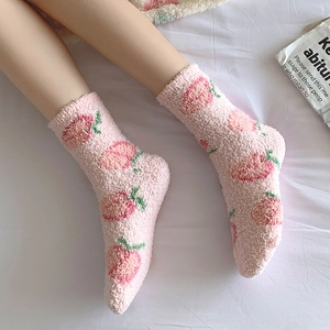 Gros plan de chaussettes épaisses en polaire corail rose à motifs de pêches mignonnes