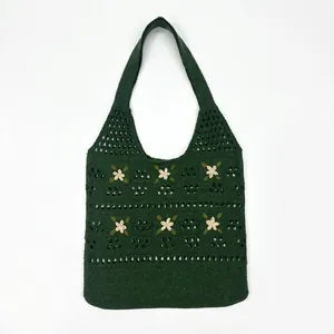 Detail of hand-crocheted dark green tote bag featuring delicate white 3D floral embroidery