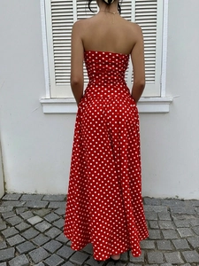Back view of a red strapless maxi dress with white polka dots on lightweight fabric