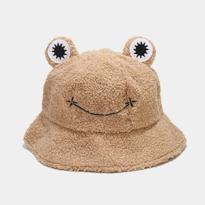 Detailed view of plush frog bucket hat in brown fleece with 3D eyes and smiling face