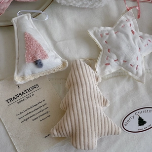 Detailed view of pink plush Christmas tree ornaments and stars with ribbon loops