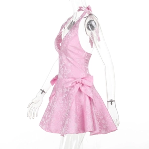Detail of pink jacquard fabric texture and side bow decoration on a halter neck dress