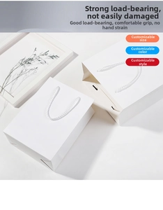 Dettaglio della busta regalo in carta bianca con resistenti manici intrecciati