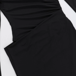 Detail of black slim fit dress with side waist cutout and ruched fabric texture