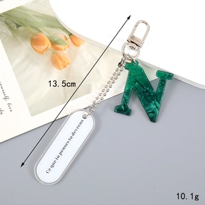 Detail of green marble acrylic letter N keychain with French quote tag and silver chain