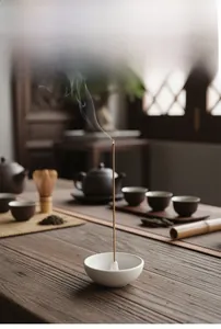 Macro detail of white ceramic incense holder on wooden table in zen tea room scene