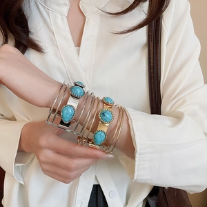 Detail of bohemian multilayer turquoise acrylic bangle with gold and silver alloy finish