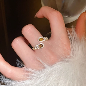 Detail of adjustable gold ring featuring tiger eye stone and sparkling zircon leaf motif