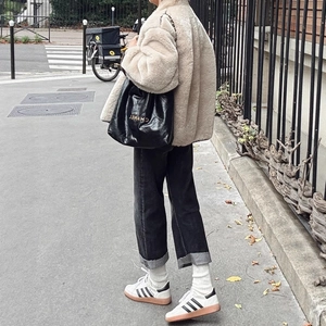 Chic oversized cream faux fur jacket with a relaxed fit shown in a city street setting