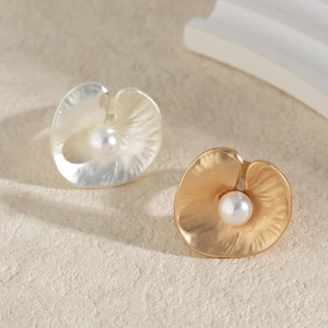 Detailed view of floral petal earrings with metallic texture and centered white pearl