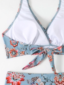 Dettaglio del retro del bikini a fiori con chiusura a fiocco e imbottiture circolari