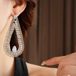 Close-up of model wearing silver hollow teardrop earrings with crystals and zircon